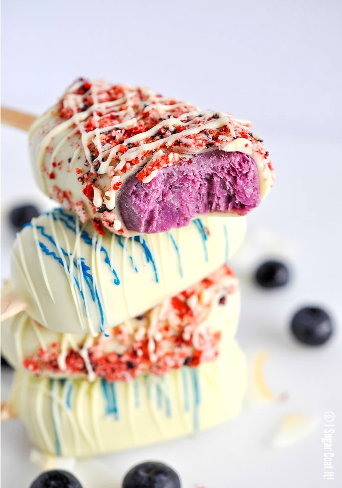 Blueberry Coconut Popsicles are a delightful blend of berries, coconut yogurt and milk dipped in decadent white chocolate and toasted coconut and freeze-dried berries.