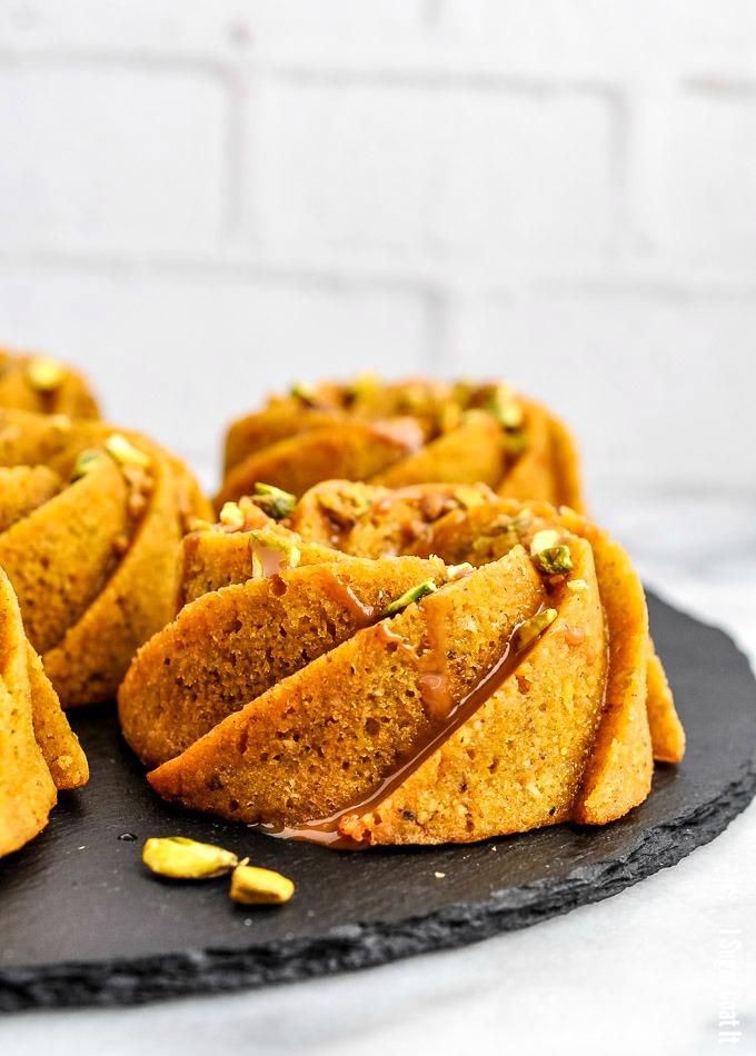 Flavour-packed, melt-in-your-mouth Pistachio Orange Caramel Mini Bundt Cakes, drizzled with orange caramel and topped with candied pistachio.